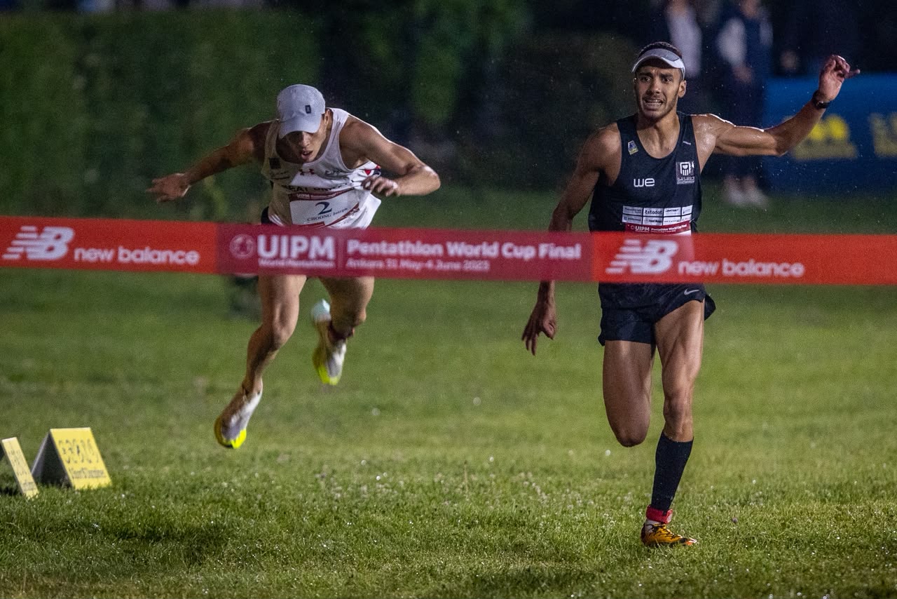 Modern pentathlon athlete running on a floodlit track at dusk